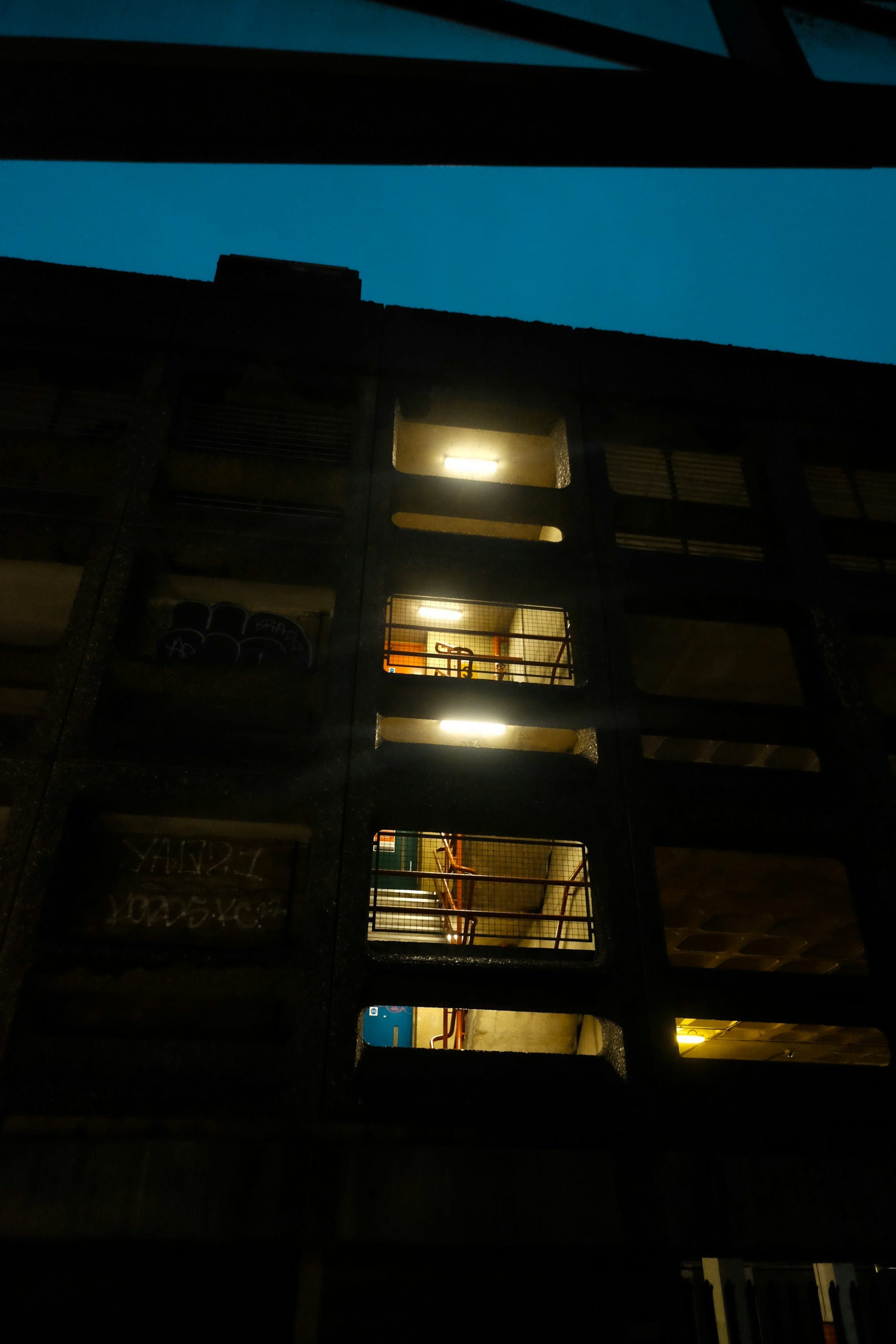 An office block in the City of London at dusk, its windows lit.